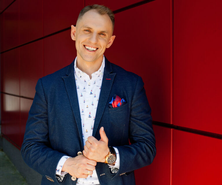 Uśmiechnięty mężczyzna przy ścianie