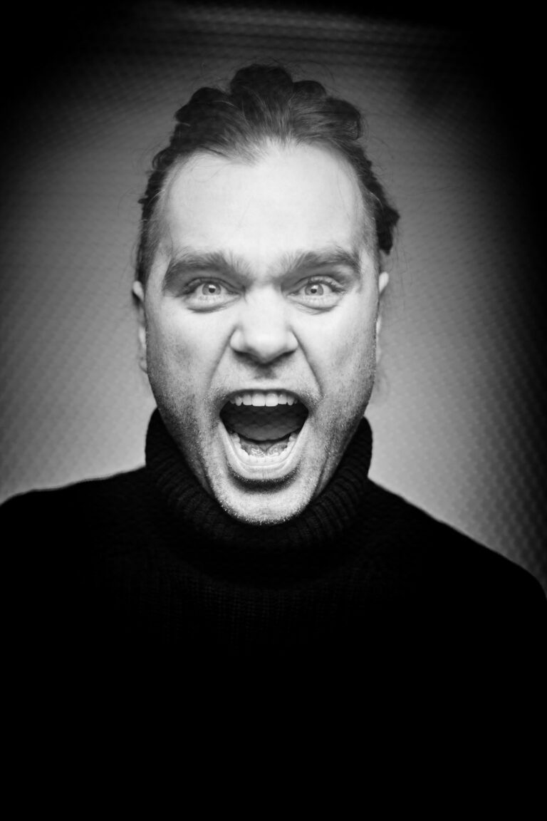 Mężczyzna w czarnym golfie krzyczący