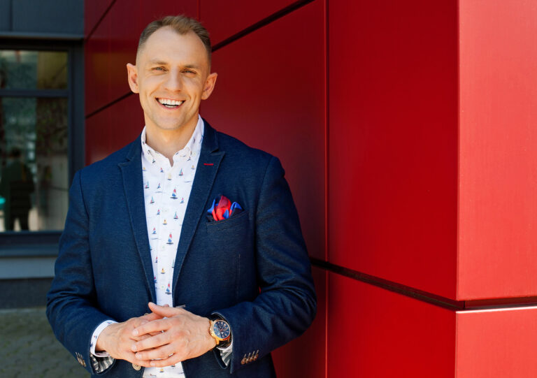 Uśmiechnięty mężczyzna przy ścianie