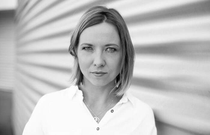 Kobieta ze spokojnym wzrokiem na tle ściany