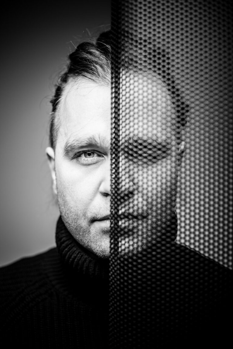 Mężczyzna częściowo za dziurkowaną płytą