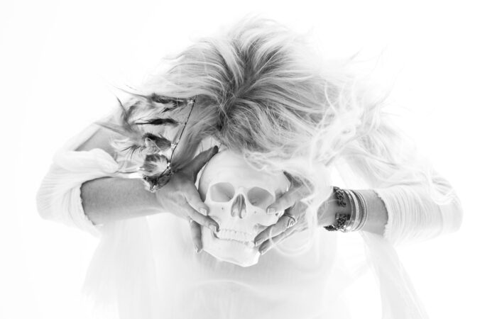 Kobieta w białej sukni na białym tle z czaszką