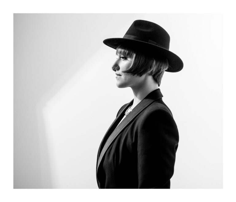 Kobieta w kapeluszu ustawiona bokiem