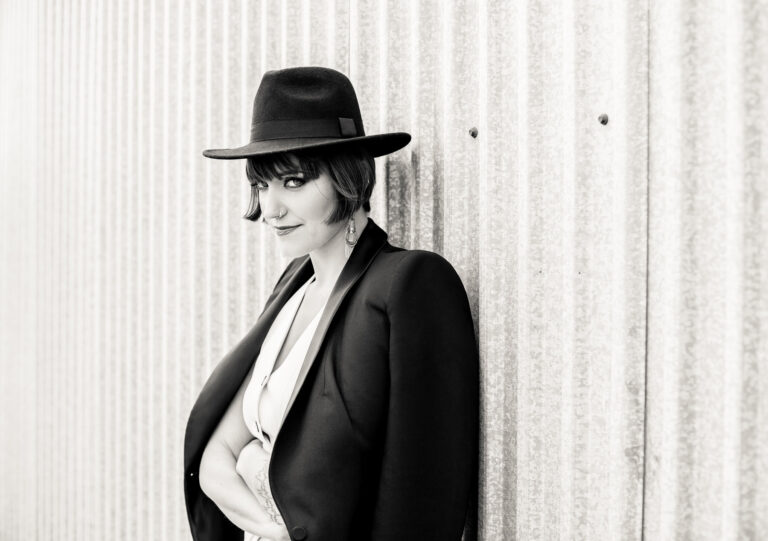 Kobieta przy ścianie patrzy w obiektyw