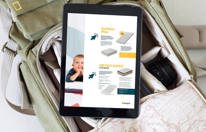 Tablet leżący na zielonej torbie z wyświetlonym na ekranie katalogiem reklamowym